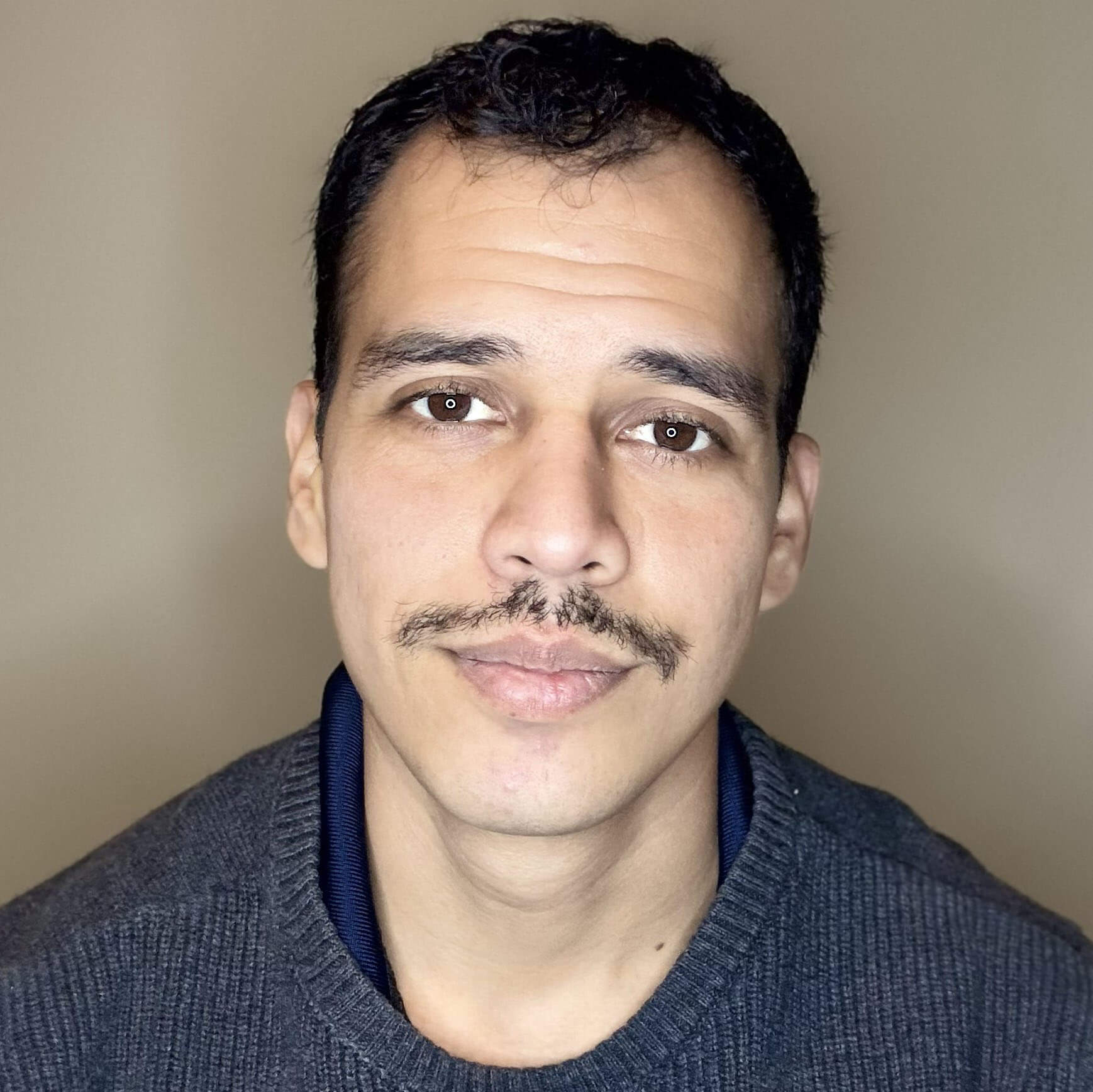 Juan Madrigal in professional attire.